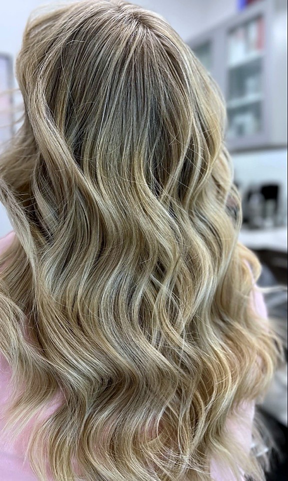 Long, sun-kissed blonde balayage styled at Hello Gorgeous Hair Lounge in Frisco, Texas